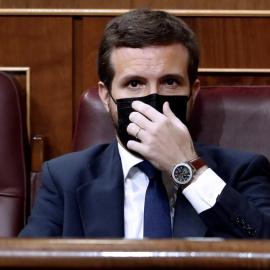 El líder del Partido Popular, Pablo Casado, se coloca la mascarilla mientras asisten a la moción de censura presentada por Vox al gobierno de coalición en el Congreso de los Diputados este miércoles. EFE/Mariscal