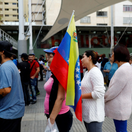 Una mujer con una bandera de Venezuela hace cola para votar en el Plebiscito (no oficial) contra el Gobierno de Nicolás Maduro.REUTERS/Andrés Martínez Casares