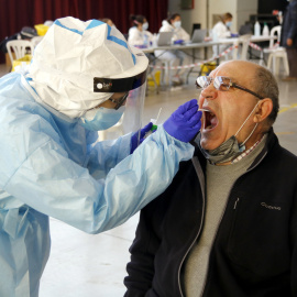 Un home es fa la prova PCR amb un tècnic sanitari al pavelló de l’Oli de les Borges Blanques. Anna Berga | ACN