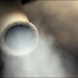 Salida de humo por el tubo de escape de un coche.