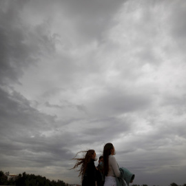Dos mujeres caminan este martes en Córdoba, en una jornada en la que la llegada de la borrasca atlántica 'Bárbara' a la península deja fuertes rachas de viento. EFE/Salas
