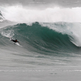 Un surfista practica surf en las grandes olas formadas en la playa de Ponzos de Ferrol.