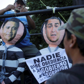 Fotografía de archivo fechada el 25 de octubre 2019 que muestra a manifestantes mientras cuelgan representaciones del presidente hondureño Juan Orlando Hernández (d) y su hermano Juan Antonio "Tony" Hernández (i) durante una protesta en Tegucigalpa (H