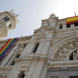 Vista de la bandera arcoirís del colectivo LGTBI (izquierda), que ha sido instalada este viernes en la fachada del Ayuntamiento de Madrid, junto a una bandera de España (derecha). /EFE
