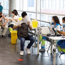 Varias personas reciben la vacuna contra la covid en el punto de vacunación masivo instalado en el Wizink Center de Madrid.