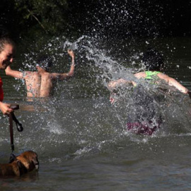 Unos jóvenes se bañan en el río Segre para combatir las altas temperaturas durante la ola de calor. / EFE