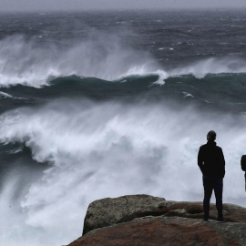 Unos turistas observan el oleaje en Muxía donde los fuertes vientos y lluvias anticipan la llegada de marejada del Atlántico en toda la cornisa cantábrica.