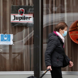 Una mujer pasa frente a un bar cerrado en Bruselas, bélgica–REUTERS