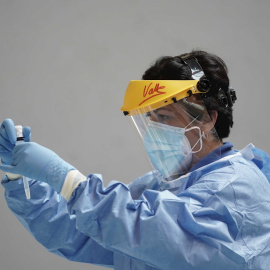 Un sanitario sostiene test rápido de antígenos en la mano.