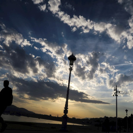 Un hombre pasea junto a la playa de Ondarreta de San Sebastián, en el que los cielos de País Vasco se presentan con chubascos.