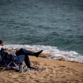 Una persona lee este miércoles en la playa de la Nova Icaria de Barcelona.