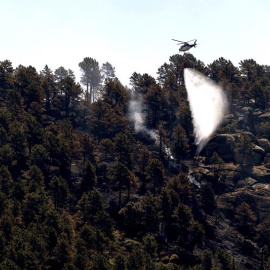 Un helicóptero trabajando en las labores de extinción del incendio en el término de El Arenal (Ávila), la Junta de Castilla y León ha rebajado el nivel de peligrosidad de los incendios que aún permanecen activos en los municipios abulenses de El Are