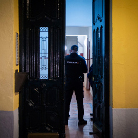 Un agente de Policía en el portal del edificio donde han hallado muerta a un joven de 20 años, a 28 de noviembre de 2022.