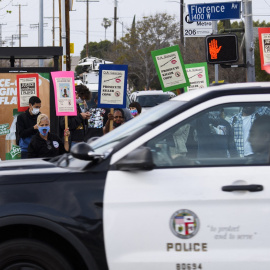 Un coche de la Policía de Los Ángeles pasa junto a una protesta por las muertes de George Floyd y Daunte Wright, a 12 de abril de 2021.