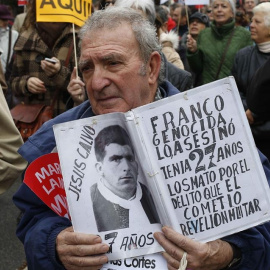 Un hombre muestra una foto de una víctima del franquismo. EFE/Paco Campos