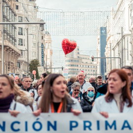Varias personas caminan con pancartas y un globo en el que pone 'Atención primaria' durante una manifestación de médicos y pediatras desde la Consejería de Sanidad hasta la sede del Gobierno regional, a 30 de noviembre de 2022, en Madrid (España).