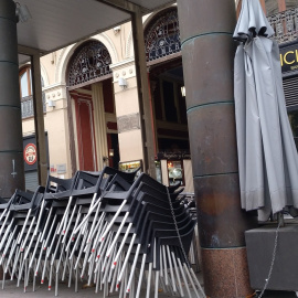 Las sillas y mesas de un bar cerrado cogen polvo a la espera de tiempos más prósperos en una céntrica plaza de Zaragoza.