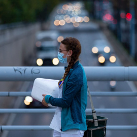 Una sanitaria camina por un puente sobre la Ronda de Dalt de Barcelona.