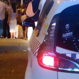 Pegatina de 'Almeida carapolla' en uno de los coches de la Policía Nacional durante las fiestas de Vicálvaro.