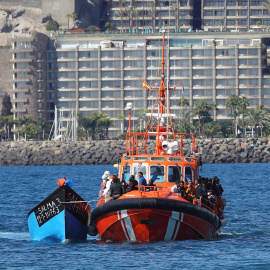 La Salvamar Menkalinan llega a los muelles de Arguineguín con los migrantes rescatados abordo y una de las pateras abarloada a su costado.