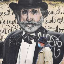 Un hombre pasa frente a un mural en Milán, Italia