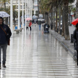 Turistas bajo la lluvia, el pasado viernes, en el paseo de Benidorm