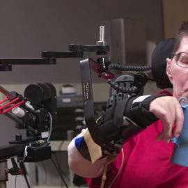 Un tetrapléjico con implantes cerebrales controla mentalmente una prótesis que le permite manejar un vaso./ CLEVELAND FES CENTER