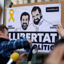 Un simpatizante de Carles Puigdemont con un cartel de apoyo a 'los Jordis' (Jordi Sánchez y Jordi Cuixart), antes de la rueda de prensa del expresident catalán en Berlín, tras su salida de una prisión alemana. REUTERS/Hannibal Hanschke
