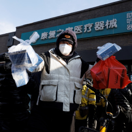 Un repartidor recoge medicamentos de una farmacia mientras continúan los brotes de la enfermedad por coronavirus (covid-19) en Pekín, el 7 de diciembre de 2022