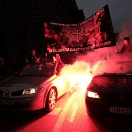 Los manifestantes sostienen una pancarta mientras viajaban en automóviles durante una marcha para conmemorar el Día de la Independencia polaca.