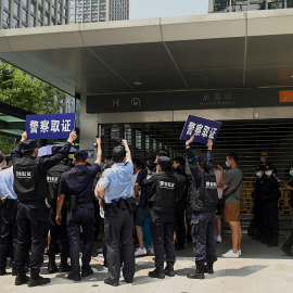 Agentes de la policía tratan de disolver la concentración de inversores y proveedores de la inmobiliaria China Evergrande, frente a su sede en la ciudad de Shenzhen, al sudeste del país, ante el temor de la que la empresa vaya a la quiebra y no les pag