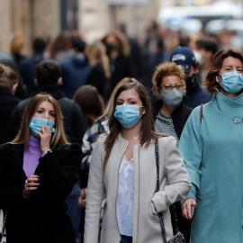 Varios transeúntes pasean por una calle de Roma, italia
