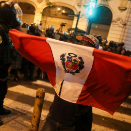 Un manifestante sostiene una bandera de Perú durante las protestas en Lima tras la proclamación del estado de emergencia, a raíz de la movilizaciones por la destitución del presidente Pedro Castillo. REUTERS/Sebastian Castaneda
