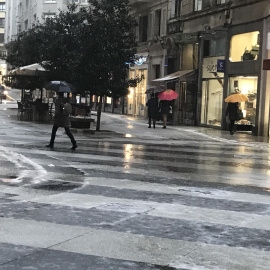 Jornada de lluvia y granizo en Santander, gente con paraguas, lluvia, frío./ EUROPA PRESS - Archivo