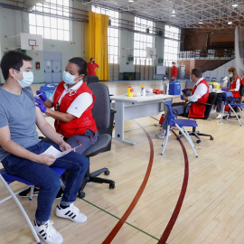 La Comunidad de Madrid comienza a vacunar contra el COVID-19 sin necesidad de cita previa en campus universitarios de la región. En la imagen, un joven recibe una dosis de la vacuna en el polideportivo de la Almudena de la Universidad Complutense (UCM), 