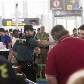 Agents de la Guàrdia Civil custodien els accessos a les portes d'embarcament. EFE/Quique García