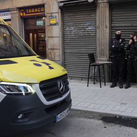 Dos agentes de la Ertzaintza en la puerta de la taberna Hiargi, donde una mujer ha sido asesinada por su pareja en Bilbao, a 28 de diciembre de 2022.