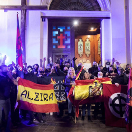 Varios ultraderechistas sostienen una bandera franquista en el acceso a la Iglesia de Benimaclet, el pasado 12 de octubre.
