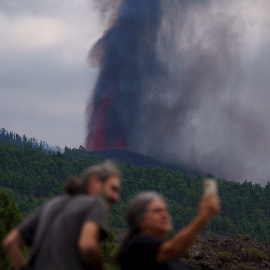 Varias personas observan la actividad de la erupción volcánica, este lunes por la tarde en La Palma, donde se esperan explosiones y gases nocivos al llegar la lava al mar.