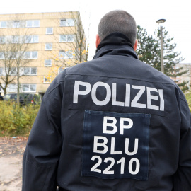 Un agente de la policía alemana frente a un edificio residencial en Schwerin. / Reuters