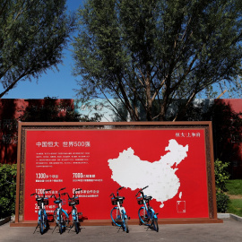 Una valla publicitaria cerca de una oficina de ventas de una promoción de viviendas de Evergrande, con un mapa que muestra los proyectos desarrollados por la inmobiliaria en el país, en Pekín. REUTERS / Carlos García Rawlins