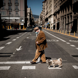 21/03/2021.- Un hombre camina junto a su perro por las calles de Barcelona. Jordi Boixareu / ZUMA Wire / Dpa