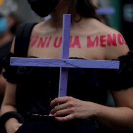 Una mujer marcha con una cruz durante una manifestación con motivo del Día Internacional de la Eliminación de la Violencia contra las Mujeres hoy, en Ciudad de Panamá
