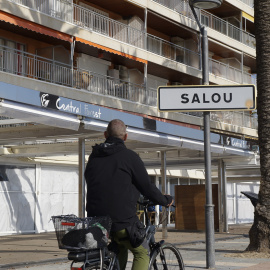 Un ciclista passa pel passeig marítim de Salou, amb els establiments tancats.