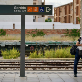 Un usuari, esperant un tren a l'andana de l'estació de Sant Vicenç de Calders