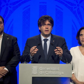 El presidente de la Generalitat, Carles Puigdemont (c), junto a la alcaldesa de Barcelona, Ada Colau (d), y el vicepresidente, Oriol Junqueras (i), hacen una declaración institucional para reprobar el atentado ocurrido esta tarde en Barcelona, un atropel