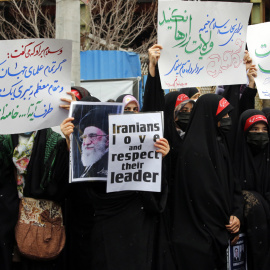 Varias mujeres sostienen pancartas y una foto del líder supremo iraní, el ayatolá Ali Khamenei, durante una protesta frente a la embajada francesa en Teherán, Irán, el 11 de enero de 2023.