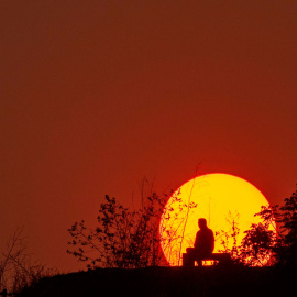 Una persona disfruta de la espectacular puesta de sol en un parque de Katmandú, en Nepal.