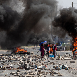 Varias personas caminan entre barricadas durante una manifestación en la ciudad de Tacna, a 11 de enero de 2023.