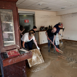 Vecinos de la localidad navarra de Tafalla limpian el interior de un local tras las fuertes lluvias caídas desde primeras horas de la tarde de ayer, que han causado importantes daños materiales en poblaciones como Olite, Pueyo, Pitillas o Beire.- EFE/Je